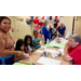 Kids learning about writing with a pen dipped in ink.