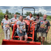 People standing around a tractor.