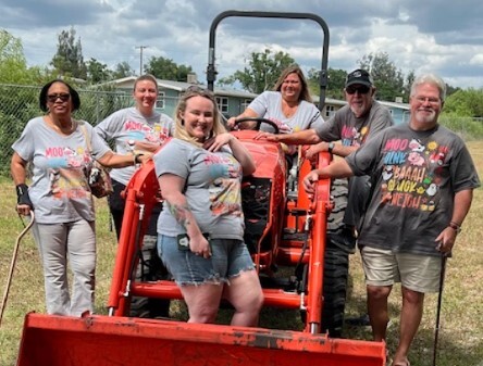 People standing around a tractor.