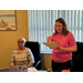 Two ladies, one seated and one standing while speaking.